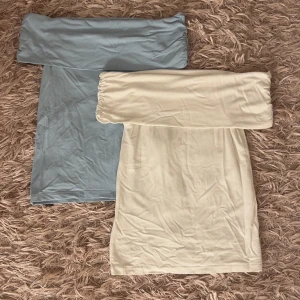 2 offshoulder toppar  - Två offshoulder toppar i ljusblått och vitt. Båda är tighta och axelbandslösa med bred kant upptill som ger en snygg och modern look. Båda är i storlek xs och jag köpte de på New Yorker. Endast använt den vita en gång och den blåa är i nyskick.