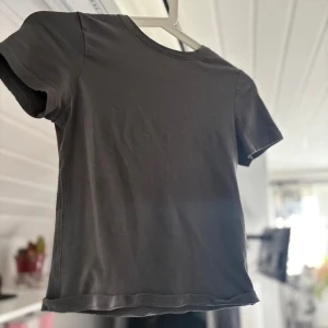 Grå basic t-shirt från H&M Divided XS - Enkel och stilren grå t-shirt från H&M Divided i storlek XS. Modellen är klassisk med rund halsringning och korta ärmar. Tillverkad i mjuk bomull som känns skön mot huden. Perfekt till jeans eller shorts för en clean look.