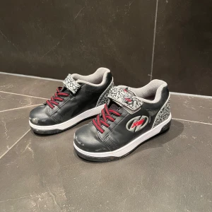 Heelys sneakers - Säljer nu ett par Heelys sneakers i färgen svart, röd och grå. Storlek 33. Skick 9/10 knappt använda. Vid fler frågor eller funderingar tveka inte att höra av dig. Priset kan diskuteras!
