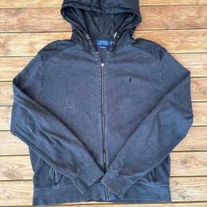 Ralph Lauren Cardigan - Tja, Fin Ralph Lauren cardigan. Storlek L, fits M. Skicket u toppklass, förutom grejen man drar dragkedjan i är borta, dock funkar det utmärkt att stänga och öppna cardiganen! Pm vid funderingar!