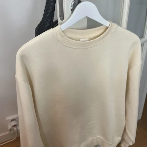 Beige sweatshirt i bomull - Jätte fin enkel och stilren beige sweatshirt med rund halsringning och ribbade muddar. Tröjan har en loose passform och är tillverkad i mjuk bomull, perfekt för en chill och avslappnad look.
