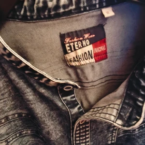 Blå/denim jeansskjorta från Eterno Fashion XL - Säljer en gråmelerad mer åt blå denim jeansskjorta från Eterno Fashion i storlek XL. Skjortan har lång ärm, knappar framtill och cool tvättad denimlook. Perfekt för dig som gillar streetstyle och vill sticka ut med en unik skjorta. Personligen bytte jag till unisex för den här är precis lika snygg som tjejen som killen.. imponerande sydd också !