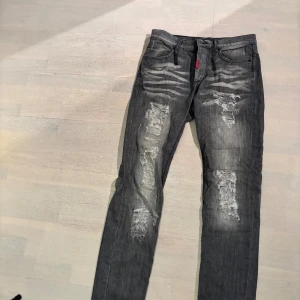 Adrian Hammond jeans  - Snygga grå jeans från Adrian Hammond med slitna detaljer. Jeansen har fem fickor och normal passform. Storleken är 33, men sitter som 32/34. 