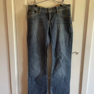 Blå jeans från Redstar med broderade fickor - Jättesnygga lågmidjade blåbootcut jeans från Redstar med coolt broderi på bakfickorna. Perfekt till skolan :) Köpte secondhand i Köpenhamn för 600kr, står ingen storlek men skulle säga 34/36 