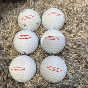 Titleist TruFeel Golfbollar (6-pack) - 6 Titleist TruFeel golfbollar i bra skick, några med mindre märken och lite slitage. Perfekt för dig som vill ha kvalitetsbollar till ett bra pris. Alla bollar är original och redo för spel. Vissa har mindre markeringar med penna.