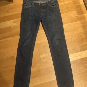 Mörkblå Lee jeans straight fit W30 L32 - Snygga mörkblå jeans från Lee med klassisk femficksdesign och raka ben. Jeansen har normal midja och är tillverkade i slitstarkt denimtyg med gul kontrastsöm. Perfekta för dig som gillar en tidlös och clean look.