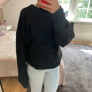 Svart stickad tröja från Nelly  - En svart stickad tröja från Nelly i storlek XS. Tröjan har rund halsringning, ribbade muddar och en loose passform. Snygg och basic stil som funkar året runt.