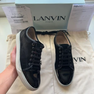 Lanvin (DBB1) cap toe  - •Färg: Svart mocka med vit sula      •Modell: DBB1, Lanvin cap toe      •Material: Mocka sko med lackad tå (cap toe)      •Storlek: UK10, ungefär EU 44.     •Skick: Mycket fint, sparsamt använd, inga defekter överhuvudtaget och skorna är som nya      •Tillbehör: Allt og — Skolåda, kvitto, extra skosnören och 2st dustbags  Kolla gärna in profilen, det finns flertalet märkeskläder och skor. Du kommer säkerligen hitta något mer intressant 😉💯