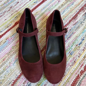 Vinröda ballerina/mary janes från Vagabond - Snygga och trendiga vinröda ballerinas från Vagabond i mjuk mocka. Skorna har rund tå, låg klack och rem med spänne över foten. Använda en handfull gånger, främst inomhus. 