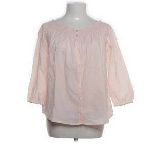 Ljusrosa blus från Rich & Royal - Supersöt ljusrosa blus från Rich & Royal med trekvartsärmar och knappar framtill. Blusen har en rundad halsringning med smockdetalj och är gjord i tunn bomull som känns luftig och skön. 