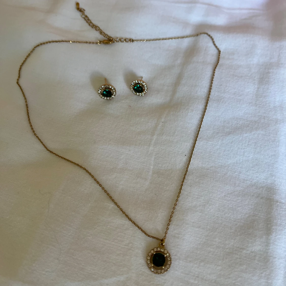 Guldigt halsband och örhängen med gröna stenar Lily and Rose