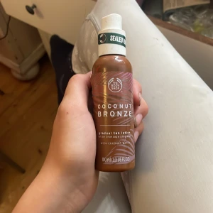 Coconut Bronze bronzer från The Body Shop - Coconut Bronze gradual tan lotion från The Body Shop, 100 ml. Ger en naturlig solkysst look med en varm brun ton. Innehåller kokosvatten och kommer i en smidig plastflaska med pump. Perfekt för att bygga upp en jämn bränna.