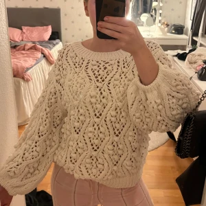 Vit stickad tröja med mönster - Säljer en superfin vit stickad tröja med grovt hålmönster och balong ärmar. Tröjan har en rund halsringning. Den är oversized och riktigt mysig att bära under kyliga dagar.