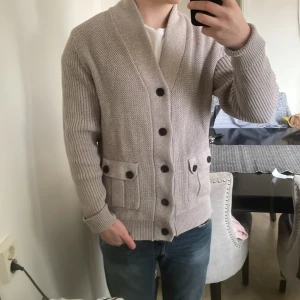 Stickad cardigan - Riktigt fet grå stickad cardigan i storlek M. Modellen är 180cm och 72kg. Priset kan diskuteras.