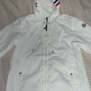 Moncler vind Jacka med huva. - Moncler vind jacka, i färgen vit. Helt ny och top kvalité. Jackan är med luva och två fickor, perfekt för vind väder/höst väder. 