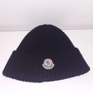 Svart mössa från Moncler - Säljer denna mössa från Moncler. Den är använd ett få tal gånger. Passar perfekt till dig som väntar in vintern.