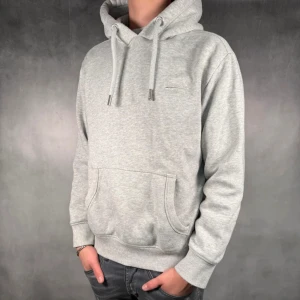 Grå hoodie från Superdry med huva - Säljer en superdry hoodie. Skick 8/10. Tröjan är nopprig lite överallt på tröjan men annars är den i fint skick. Skriv vid funderingar