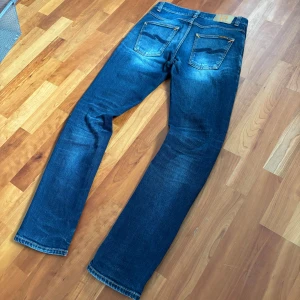 Blå jeans från Nudie Jeans - Snygga blå jeans från Nudie Jeans. Modellen på bild är 173 63kg. Passar nog bättre på någon som väger lite mindre!