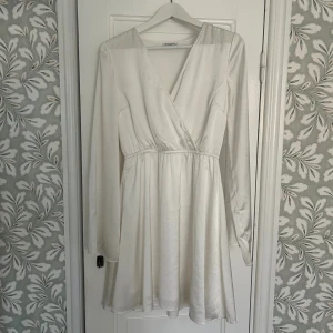 Studentklänning - Säljer min vita studentklänning. V-ringad och breda armar. Använd en gång och i fint skick.