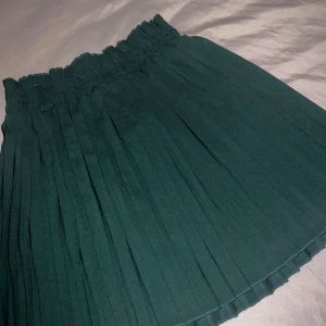 Mörkgrön plisserad kortkjol - Aldrig använd, går att sätta på bälte 