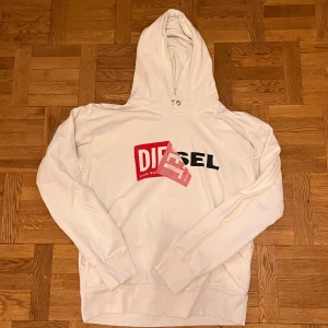 Vit hoodie från Diesel XS - Säljer en vit hoodie från Diesel i storlek XS. Tröjan har en stor huva och snygg design på bröstet. Använd ett fåtal gånger och har inga skavanker.