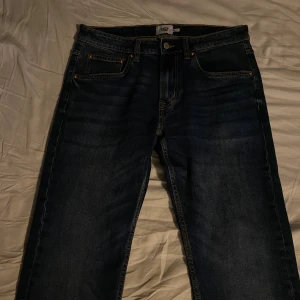 Mörkblå slim jeans från 157 - Snygga mörkblå jeans från 157 med slim passform. Klassisk femficksdesign, kontrastsömmar och knappstängning fram. Jeansen har raka ben och är tillverkade i slitstarkt denimtyg. Perfekta för dig som gillar en smalare siluett.