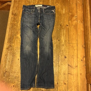 Replay blå jeans straight fit - Snygga blå jeans från Replay i storlek w 33  med klassisk straight fit och kontrastsömmar. Jeansen har fem fickor, detaljerad Replay-logga på bakfickan och läderpatch i midjan. Materialet är slitstarkt denim och passformen är normal med raka ben.
