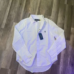 Ralph lauren skjorta - Säljer denna vita linnen ralph lauren skjorta i storlek S. Den är helt ny och har sin tagg på! säljer då den var för liten för mig. Hör av er om ni har funderingar eller vill ha fler bilder så svarar jag direkt!
