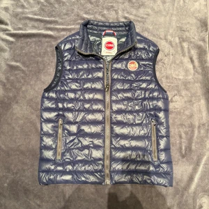 Colmar väst - Säljer en colmar väst i en glansig marinblå färg som är perfekt för alla årstider. Skick 9/10. Den är i storlek M men passar även S. Hör av dig om du har frågor eller funderingar❕