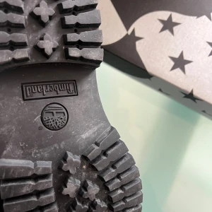 Svarta Timberland boots i svart  - Timberland boots i helsvart  med grov sula och snörning. Klassisk rund tå och vadderad krage för extra komfort. Perfekt för dig som gillar streetstyle och robusta skor med attityd. Snyggt Timberland-märke på sidan och slitstark design.