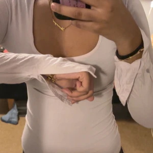 Ljusrosa långärmad topp med fyrkantig ringning - Säljer en ljusrosa långärmad topp med snygg fyrkantig ringning och tight passform. Toppen är enkel och stilren, perfekt att matcha med jeans eller kjol. Materialet känns mjukt och stretchigt, vilket gör den bekväm att bära hela dagen. Sitter tight på mig som är S. Har en liten gel fläck på armen 