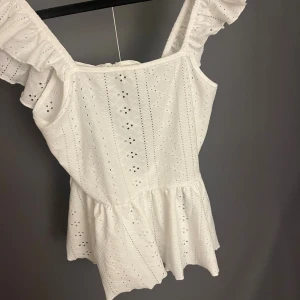 Topp  - Söt topp/linne med volanger. Inga defekter eller något. Kan tyvärr inte visa på då den ej passar. 