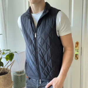 Oscar Jacobson väst mörkblå - Oscar Jacobson väst mörkblå i storlek M/ S, mer en S. Mindre i allmänhet än den andra västen jag har. Modellen är 180 cm 75 kg och passar honom bra! Inga som helst defekter 🫶 är skön nu tilll vintern