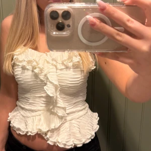 Volang topp - Supersöt vit linnetopp med tunna axelband och volangdetaljer både upptill och nertill. Aldrig använd med prislappen kvar!