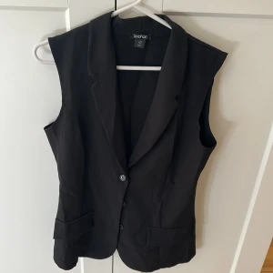Svart väst med knappar - Stilren svart väst med klassisk krage och knäppning framtill.  Oavsvänd 