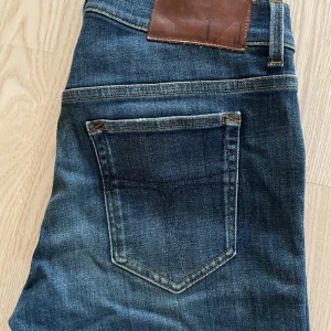 Tiger Of Sweden 32/30 - Riktigt fina Tiger Of Sweden jeans i ett bra skick i strl 32/30! Klassiska jeans färgen med hål på båda knäna. Nypris-1199kr