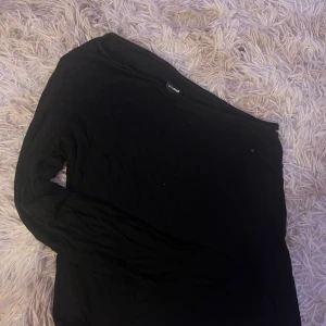 Svart långärmad tröja från Gina tricot - En enkel svart långärmad tröja från Gina tricot. Tröjan har rund halsringning och är tillverkad i mjukt bomullsmaterial. Perfekt att matcha med jeans eller kjol för en clean look.