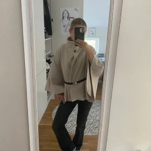Poncho jacka.  - Säljer den i nyskick! Köpte innan sommaren och endast använd någon enstaka gång. Jag bytte knapp och bälte på den. BÄLTET INGÅR EJ. Köptes för runt 400kr på rea tror jag. Storlek onesize det passar till de flesta.