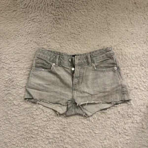 Grå jeansshorts - Säljer ett par ljusblå jeansshorts från Lager som har slutat komma til användning. Shortsen är lågmidjade, och ser lite skrynkliga ut endast eftersom de har legat i garderoben ett tag Perfekta till sommaren och ger en chill vibe till din outfit.