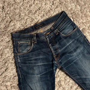 Nudie Dry Selvage Jeans - Säljer dessa riktigt snygga Nudie jeans i modellen Steady Eddie dry Selvage jeans. Snyggt lagade i skrevet, kan skicka bild vid intresse. Har fått riktigt feta fades och är i storlek 30/32 men passar mer 30/31. Bara att skriva över frågor och funderingar