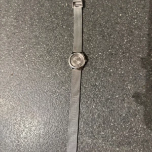 Silver klocka från Calvin Klein - Snygg och stilren klocka från Calvin Klein i silverfärgat rostfritt stål. Den har ett runt ur med minimalistisk design och ett mesharmband som ger en modern vibe. Perfekt för dig som gillar enkel och klassisk stil. One Size.