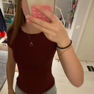 Vinröd tight topp med kort ärm - Säljer en enkel och stilren vinröd topp med tight passform från lager 157. Toppen har rund halsringning och korta ärmar, perfekt att matcha med jeans eller kjol. Materialet känns mjukt och stretchigt, vilket gör den riktigt bekväm att bära.