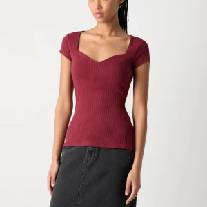 Vinröd ribbad topp med v-ringning - Säljer en vinröd ribbad topp med snygg v-ringad hals och korta ärmar. Storlek S och säljer pga av att den inte kommer till användning💕