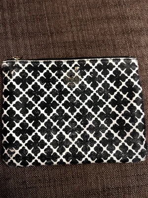 Svartvit mönstrad kuvertväska från Malene Birger  - Den har använts men är ganska sliten i utseendet. Den har b.la. Märken på den och färgen hos de svarta har flagranta bort lite grann.jag har tvättat den en gång och fått bort en massa men den har fortfarande märken på den. Jag hade rekommenderat å ta den till en skräddare som kanske kan fixa dessa grejer. Märket är upplöst i ett av fyra hör , dock så håller den fortfarande. Och bandet i blixtlåset är borta. Men allt som allt är den fortfarande otroligt fin och kan absolut användas. 