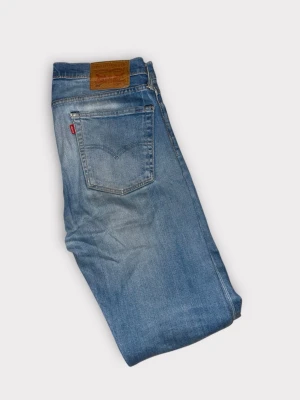 Levi's 510 blå skinny jeans - Säljer ett par Levi's 510 jeans i klassisk blå tvätt med skinny passform. Jeansen har fem fickor, knapp och dragkedja fram samt den ikoniska Levi's-lappen bak. Materialet är slitstarkt denim och modellen är smal hela vägen ner.