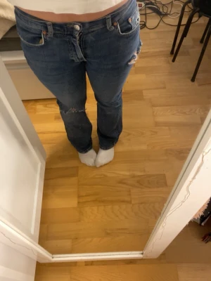 Jeans bootcut - Säljer ett par blå jeans med slitningar. Jättesnygga och jättesköna. Skriv om du har några frågor😇
