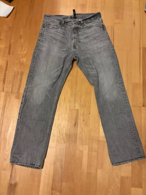 Weekday jeans grå - Säljer ett par klassiska grås weekday jeans med raka ben och sjukt wash. Jeansen har en tidlös look med knappgylf och är tillverkade i slitstarkt bomullsdenim. Perfekta för dig som gillar en avslappnad och enkel stil.