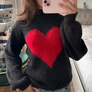 Svart stickad tröja med rött hjärta - Jättesnygg svart stickad tröja med ett rött hjärta på framsidan. Så cool och såå skön tröja🤩🤩Tröjan är i storlek S från Kappahl🥰 Lånade bilder så skriv om du vill ha egna💓