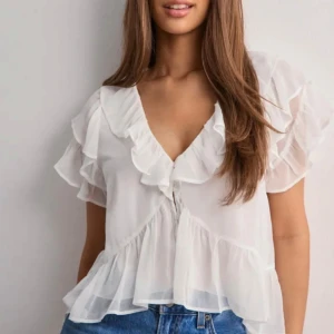 Vit volangblus med v-ringning - Säljer en superfin vit blus från Nelly! Oanvänd så i nyskick!!!😍😍 