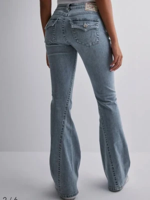True Religion lågmidjade bootcut jeans - Ljusblå lågmidjade jeans från True Religion med bootcut passform. Uppsydda av skräddare för att passa mig 162cm! Skiv gärna om frågor💕använda fåtal gånger och ser fortfarande nya ut!